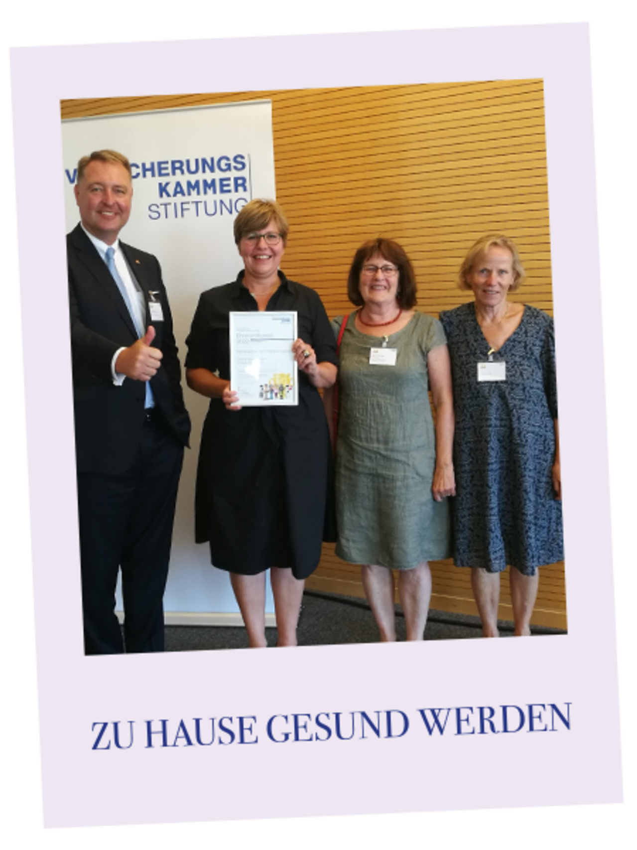 Ausgezeichnetes Engagement: Ein Mann und drei Frauen von ZuhauseGesundWerden zeigen die Urkunde der Auszeichnunggen die Urkund