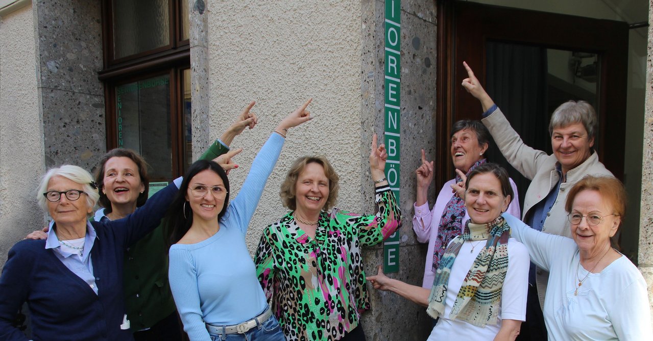 Frauengruppe vor Schild Seniorenbörse - Begegnung fördert Austausch und Lebenslust