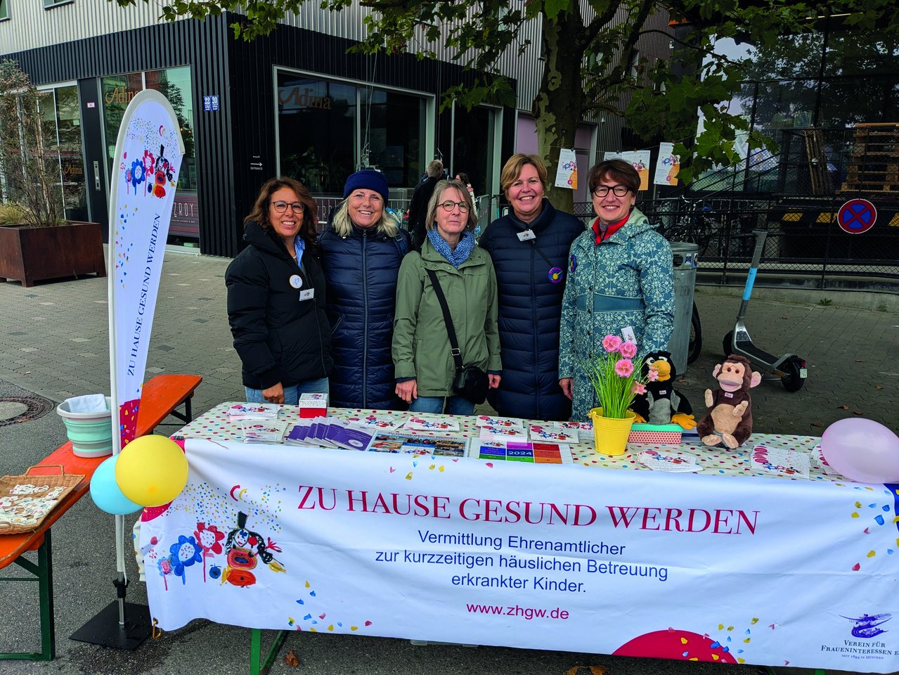 Frauengruppe vor Plakat - kranke Kinder werden von erfahrenen ehrenamtlichen Frauen betreut